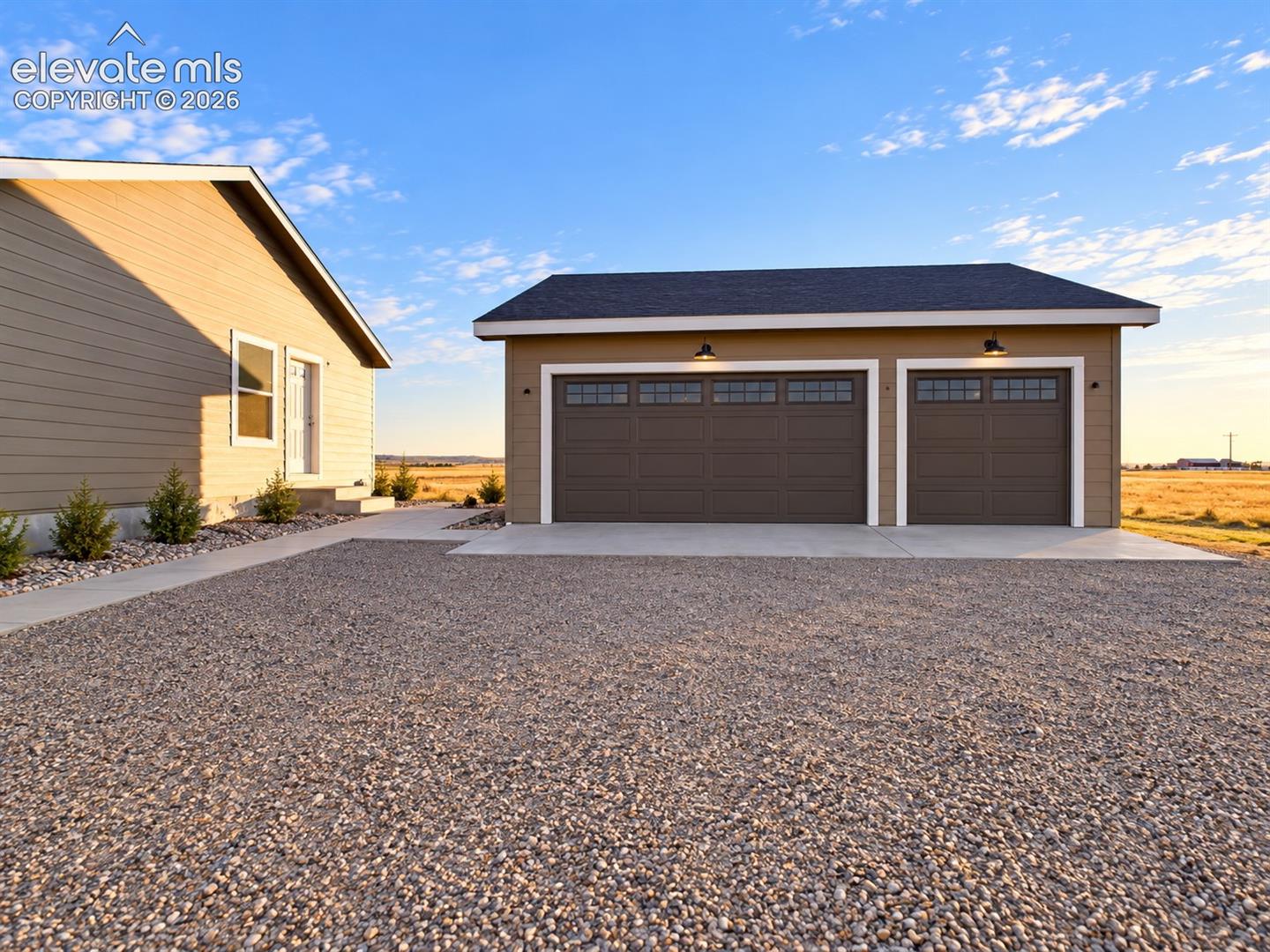 Detached Garage – Detached 3 car garage provides substantial additional parking and storage space, conveniently positioned near the home with a broad gravel approach.