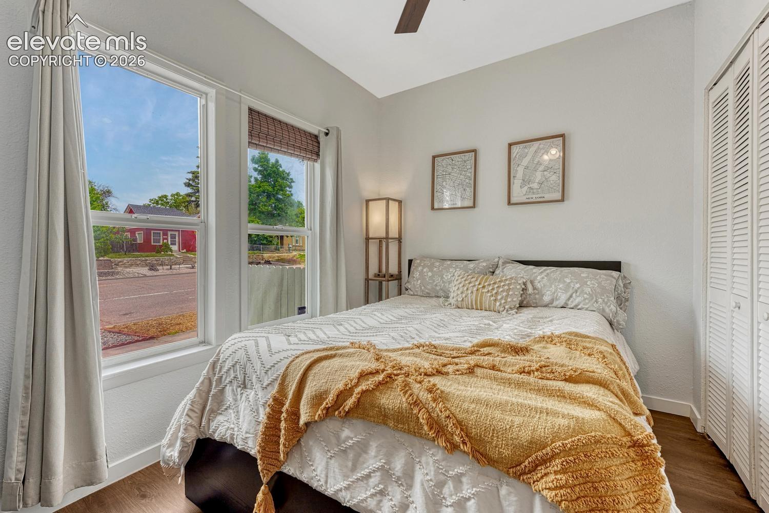 Wood-finish flooring, white walls, and a ceiling fan with integrated lighting