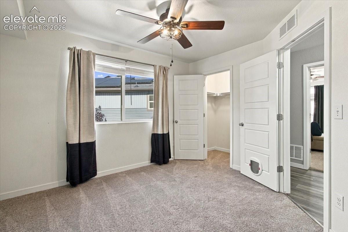 Recessed window with natural light, ceiling fan with integrated lighting, built-in closet, and gray carpeting