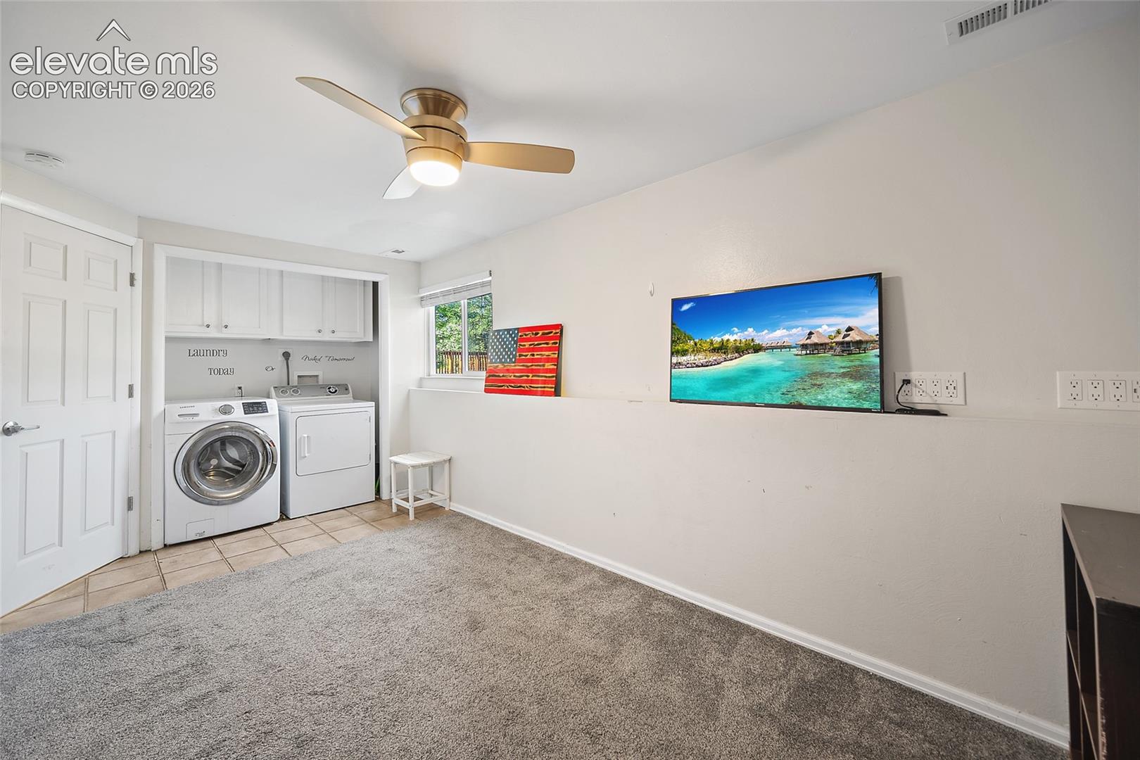 Laundry area with upper storage cabinets.