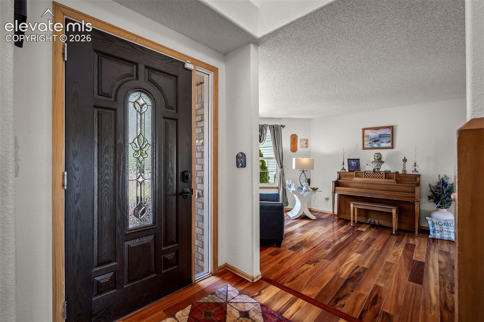 Entryway featuring a dark paneled door with decorative leaded glass.

