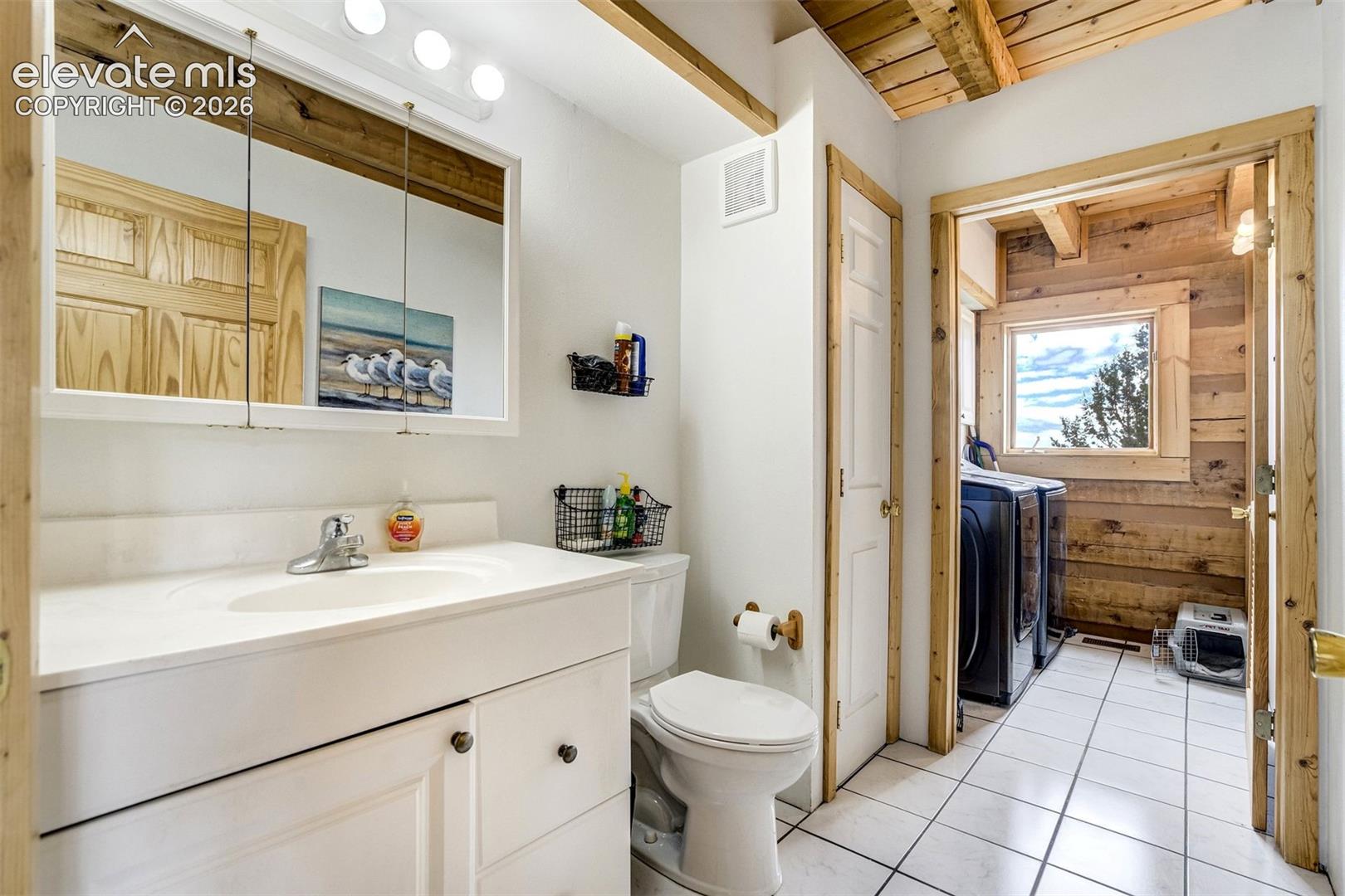 Bathroom with a white vanity featuring an integrated sink and base cabinetry, complemented by a medicine cabinet with integrated lighting
