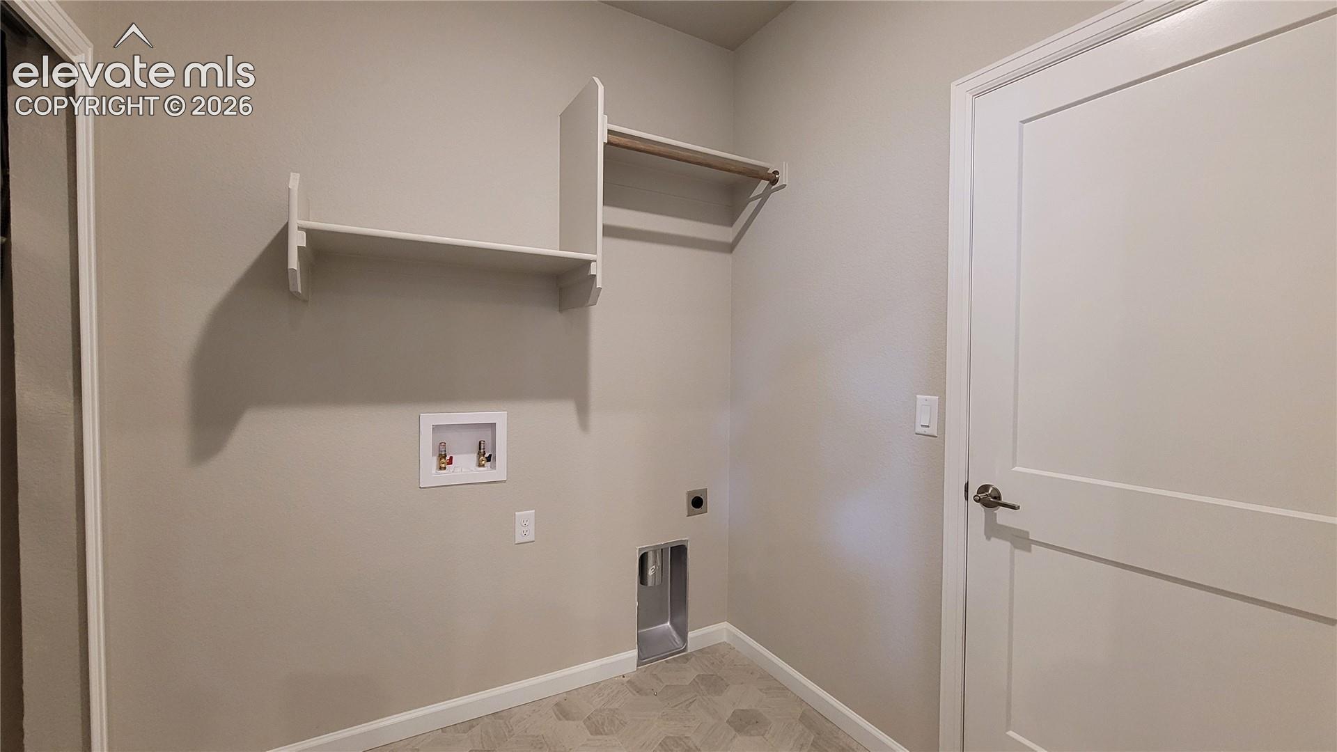 Main Level Laundry with wood shelving and rod, access to the garage, right off the kitchen! 