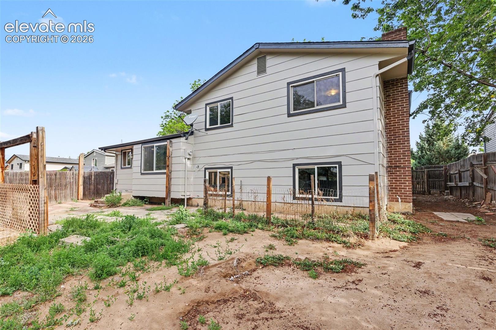 Rear exterior showcasing the home's tri level layout and backyard space.