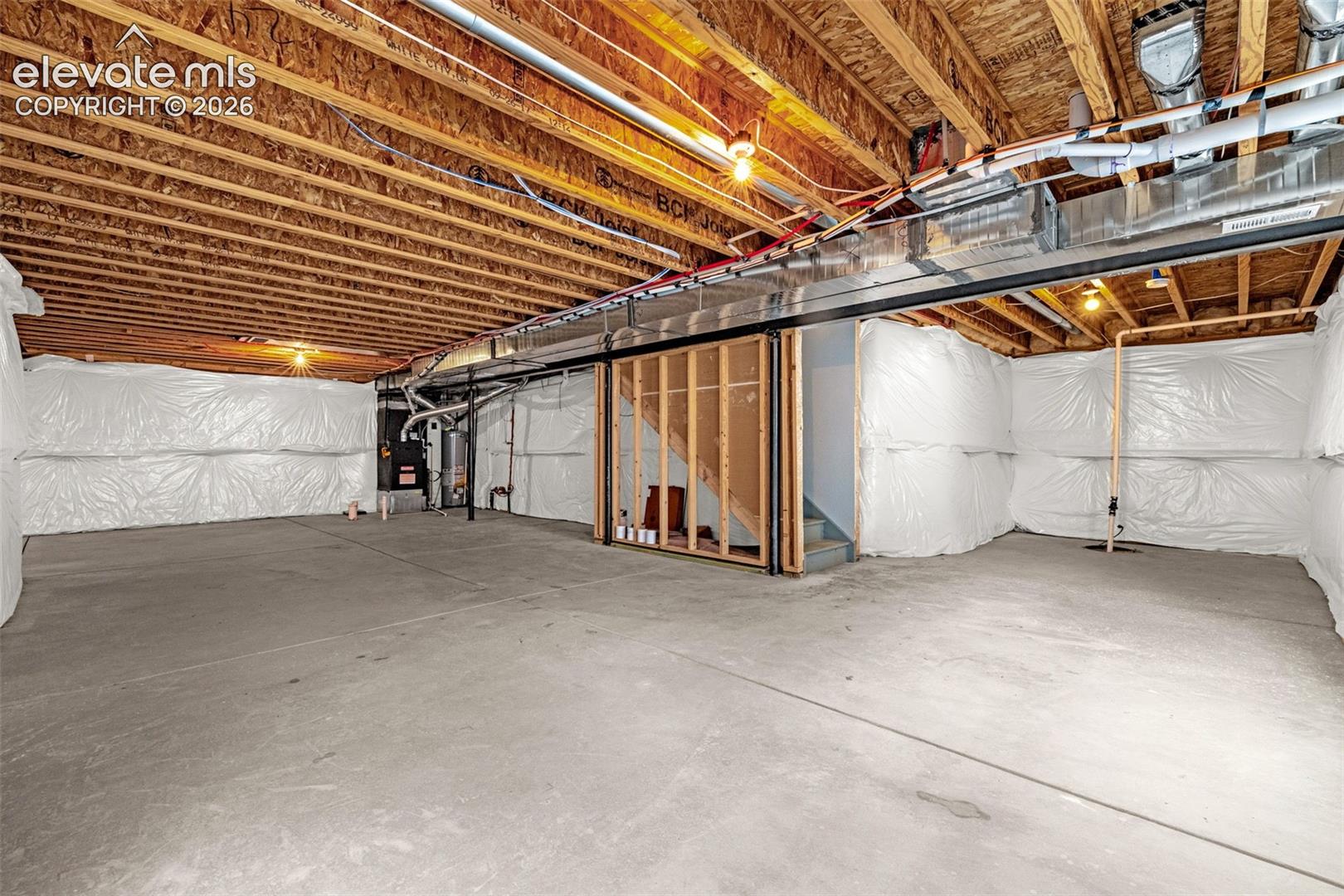 Unfinished basement with concrete flooring and exposed ceiling joists