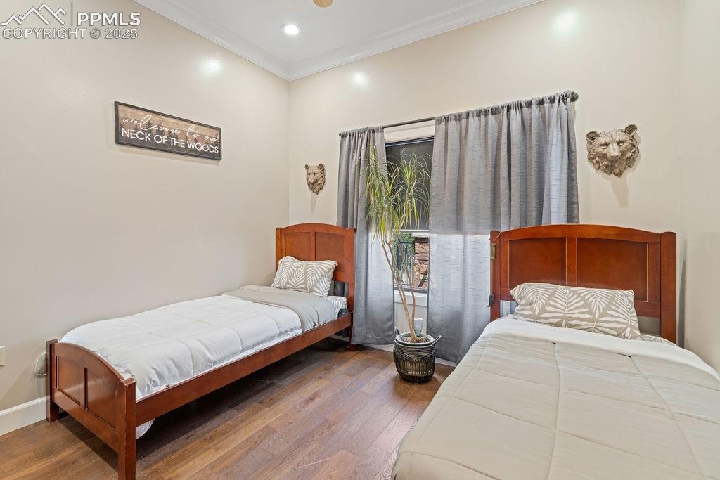 Bedroom featuring ornamental molding, dark wood-style floors, and recessed lighting