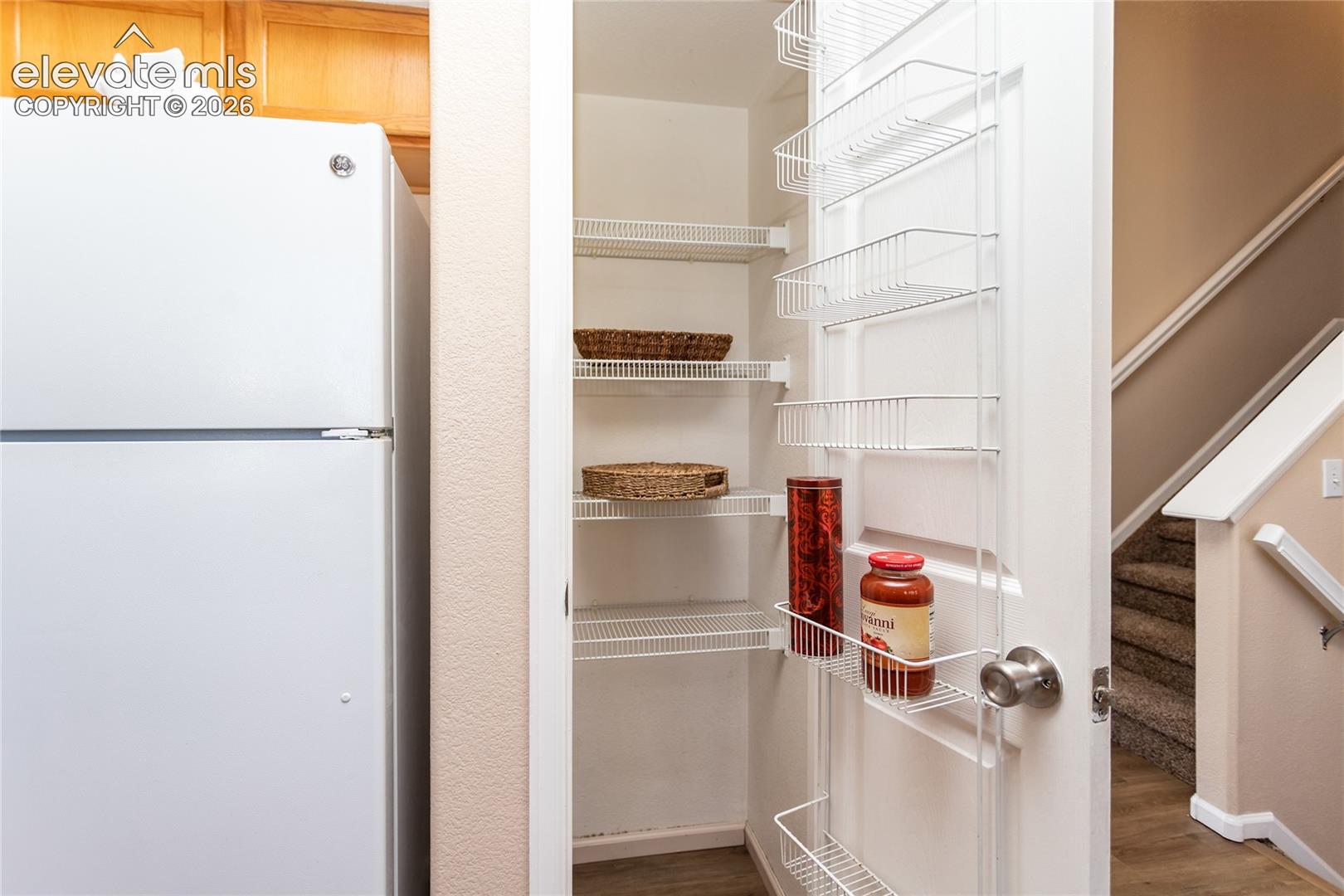 A built-in kitchen pantry closet provides convenient food storage shelving
