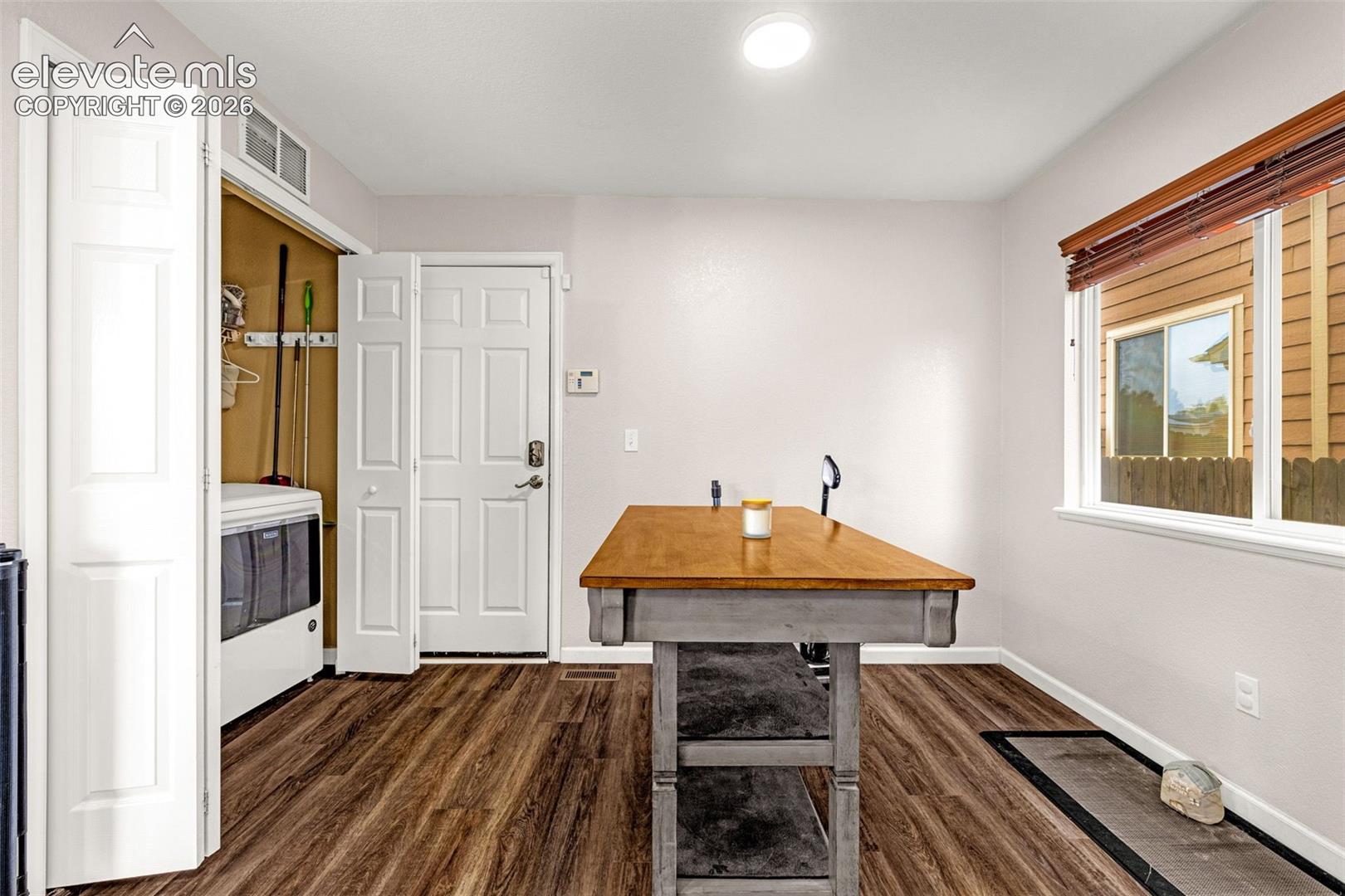 Laundry area with wood-finish flooring, recessed ceiling lighting, and a bi-fold door closet