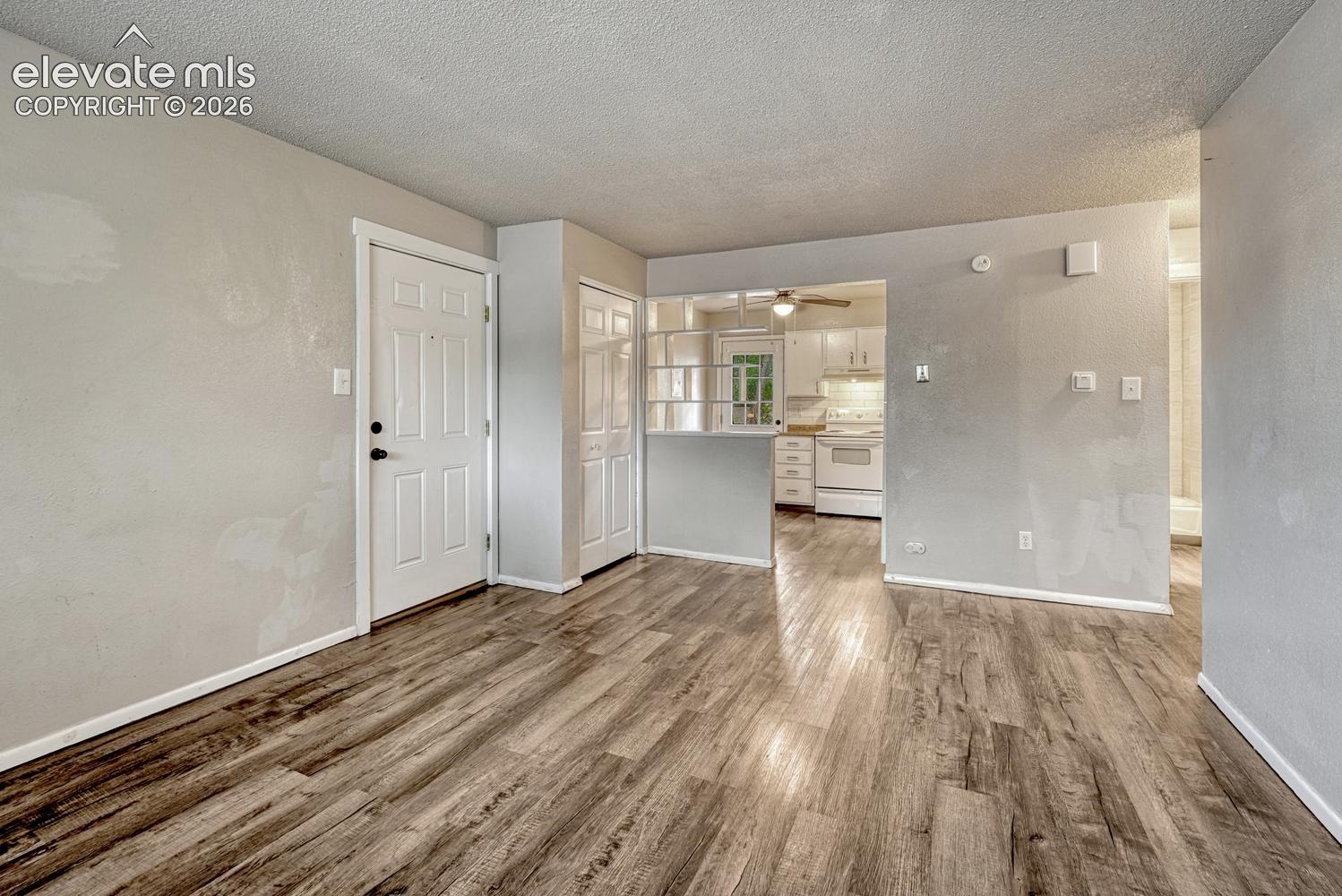 Wood-finish flooring throughout, white paneled doors, and a partial wall separating spaces