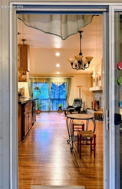 Spacious interior featuring wood-finish flooring, a chandelier with amber glass shades, and recessed ceiling lighting