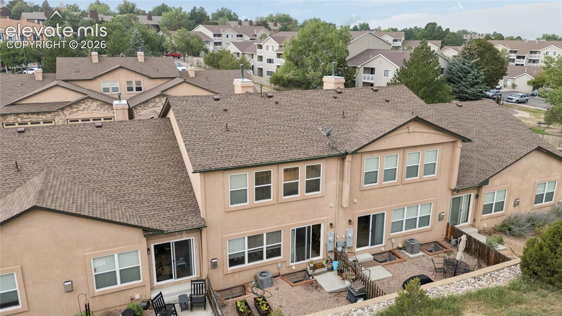 Rear exterior featuring stucco finish, multiple sliding glass doors, upper-level windows, and an outdoor patio space