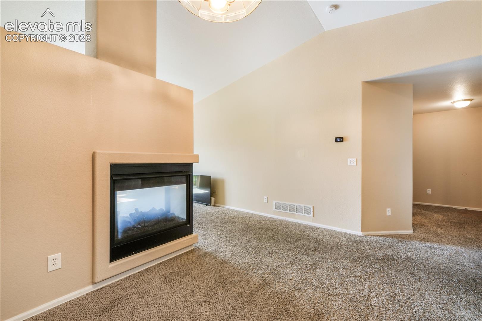 Three sided gas fireplace between dining area and living room