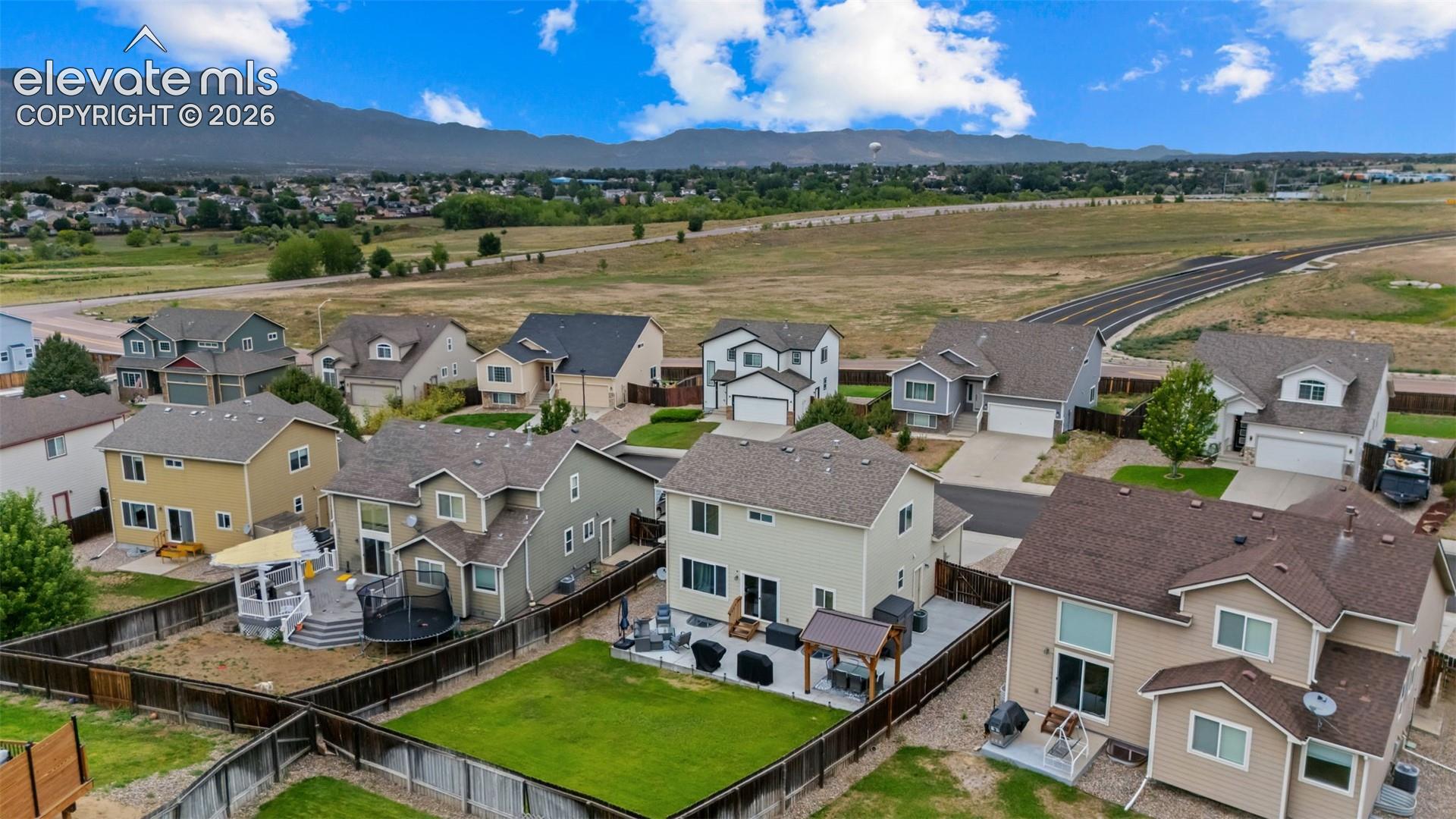 Residential neighborhood with established homes, mountain backdrop, and expansive open space