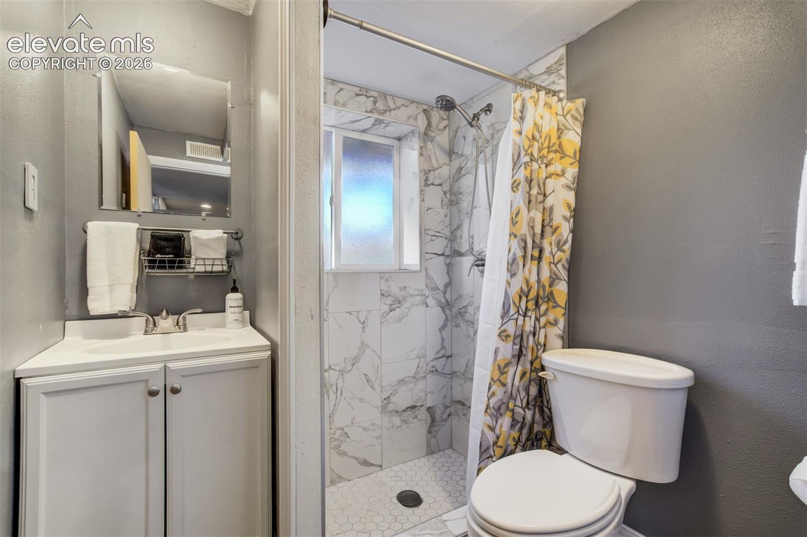 White vanity with a rectangular sink and chrome faucet