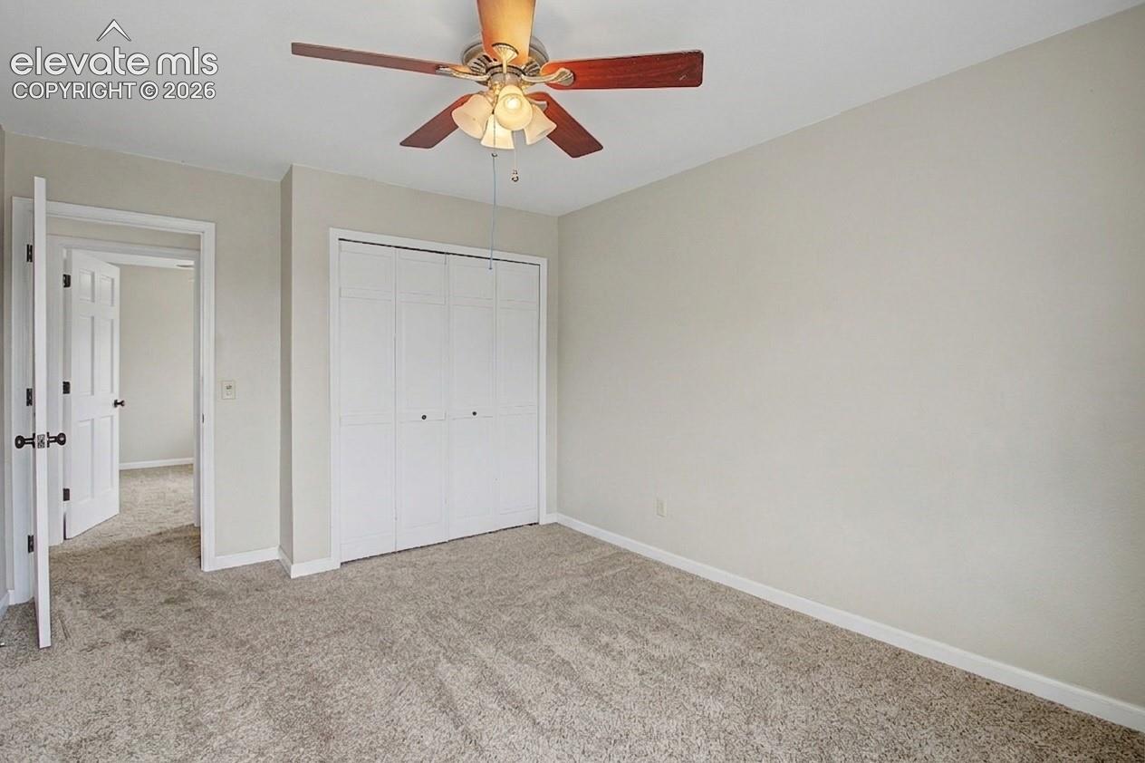 Room featuring a ceiling fan, light gray wall paint, white trim, and light-colored carpet flooring