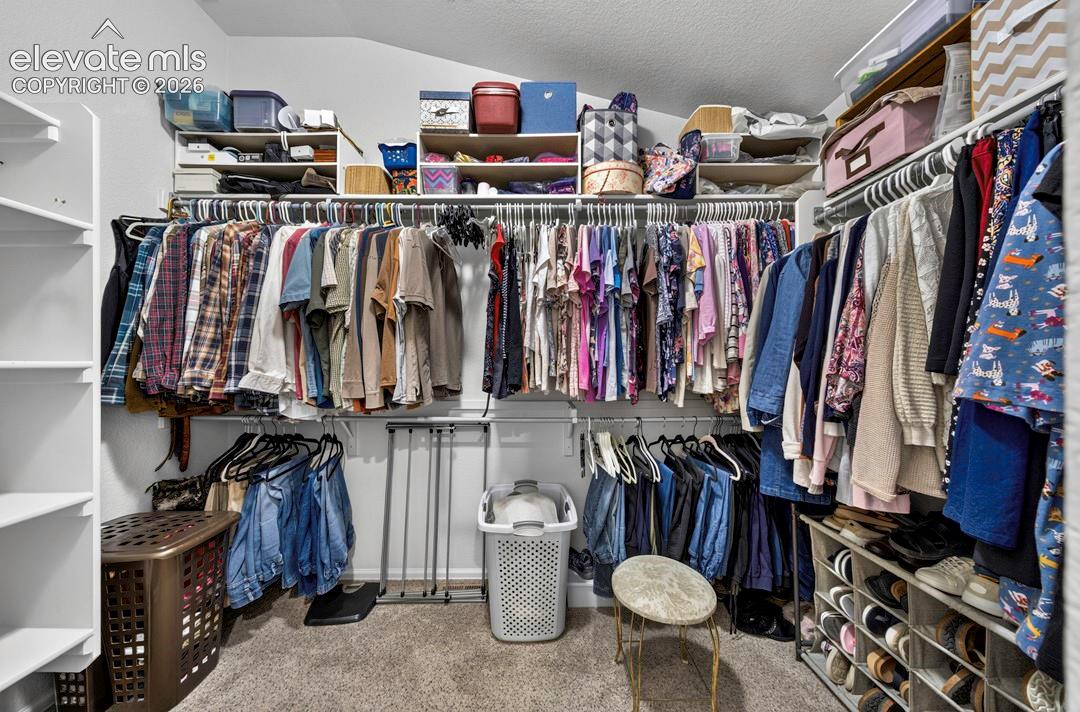 Custom closet system featuring multiple hanging rods, integrated shelving, and shoe storage