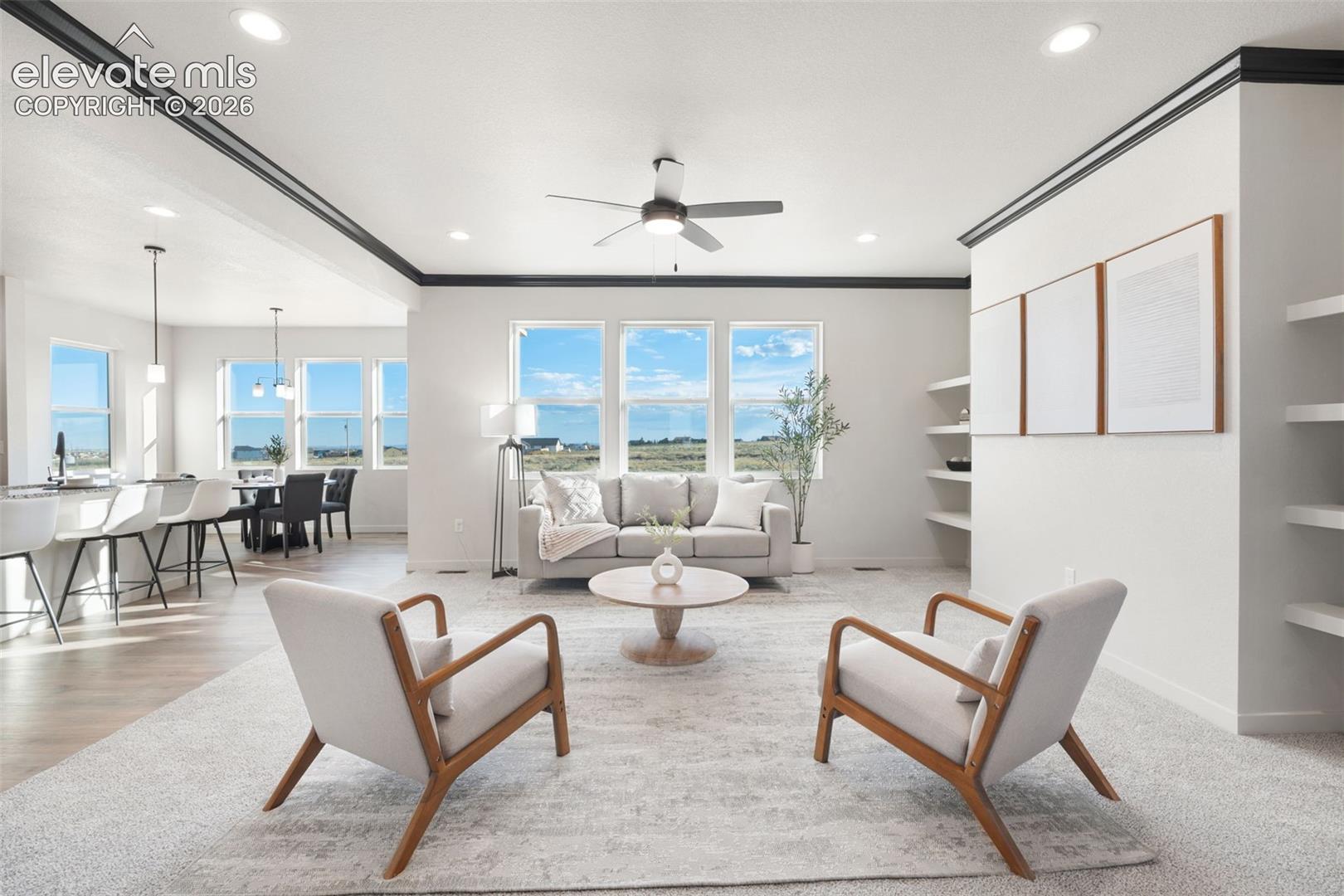 Recessed lighting, ceiling fan, crown molding, built-in shelving, and multiple windows