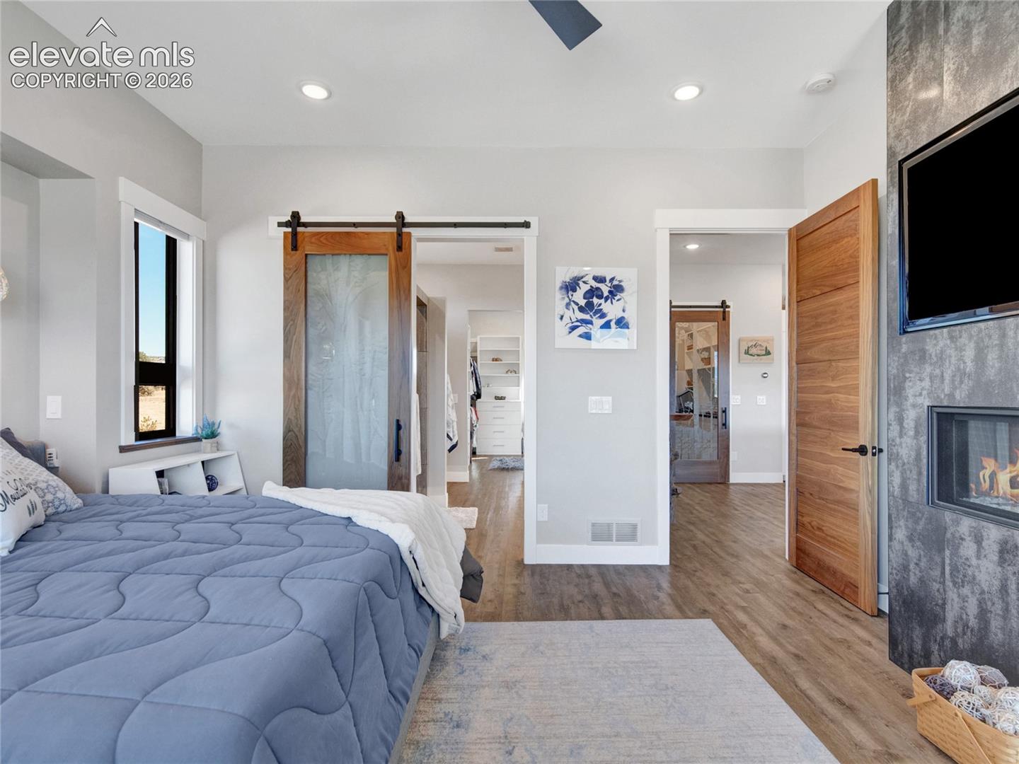 Primary bedroom with a modern ceiling fan and gas fireplace.