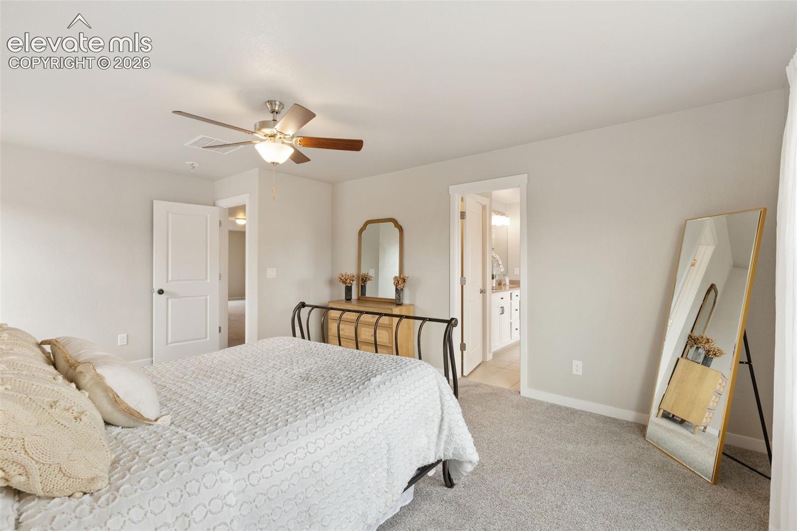 Carpeted room featuring a ceiling fan with light fixture, light gray wall paint, and white trim