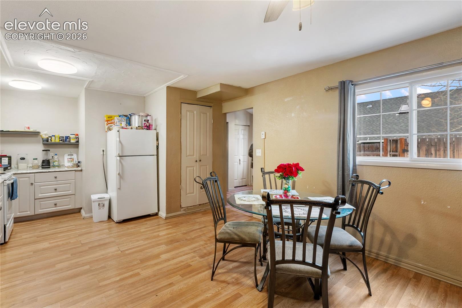 Kitchen featuring wood-finish flooring, white cabinetry with integrated drawer hardware, and a window with muntin dividers