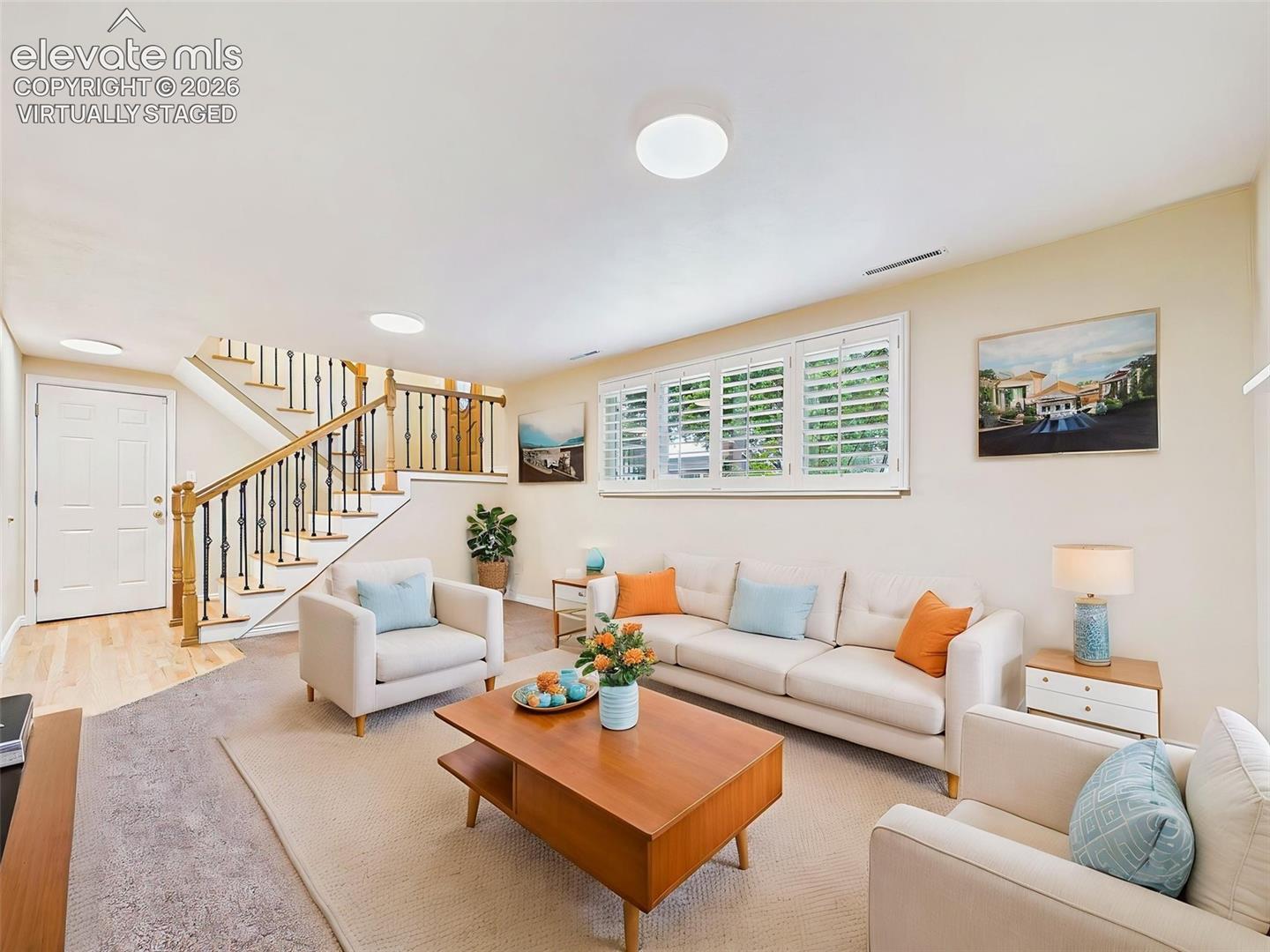 (Virtually Staged)Family Room – Alternate perspective showcases the seamless connection between the family room and staircase, with hardwood flooring at the entry adding warmth and character.