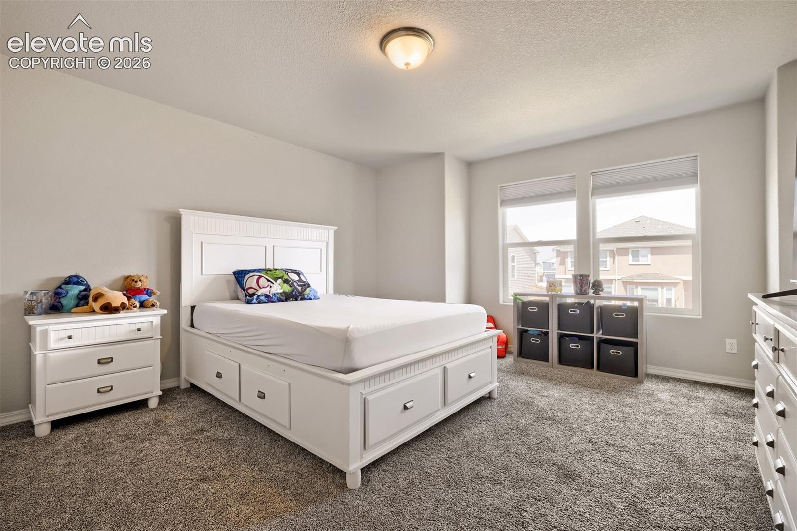 Bedroom featuring light grey walls and grey carpet flooring