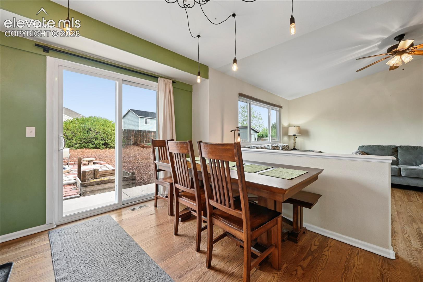 Dining room in the middle of the main living areas with a full glass patio door leading to outdoor patio spaces