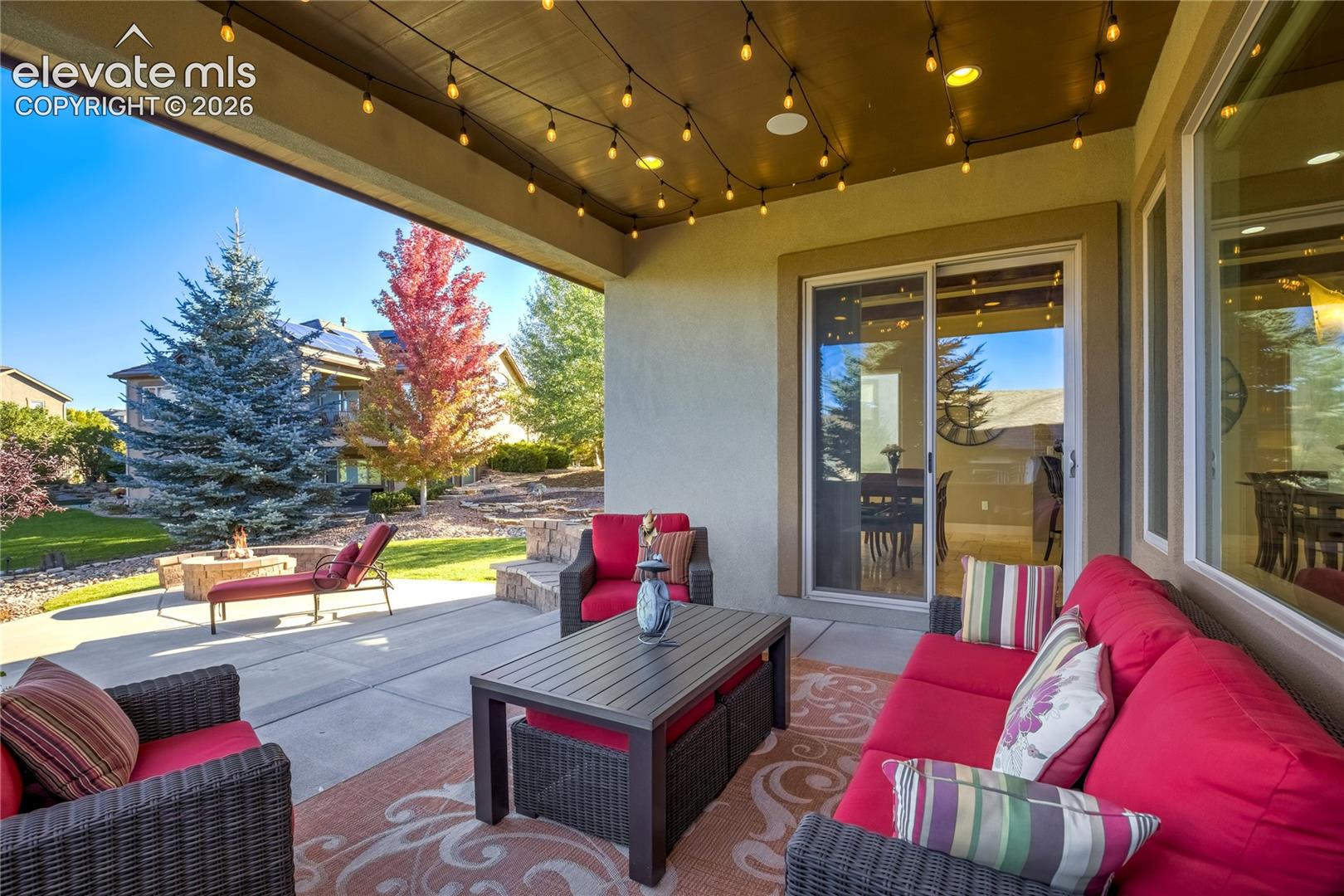 The covered patio features a remote-controlled sunshade, integrated speakers + gas connection for grilling, extending the home's entertaining spaces outdoors.