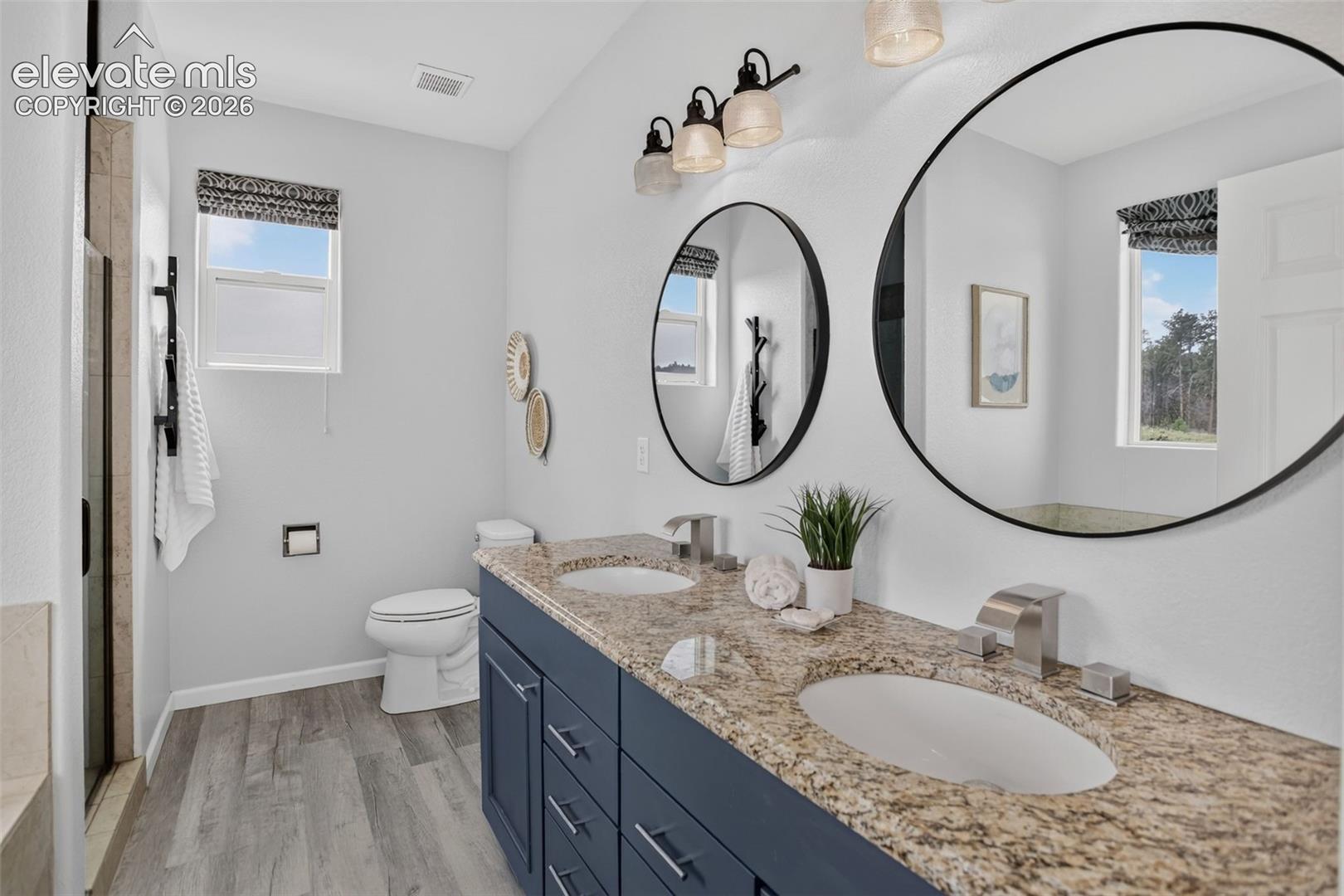 Primary bathroom with double sink granite countertops.