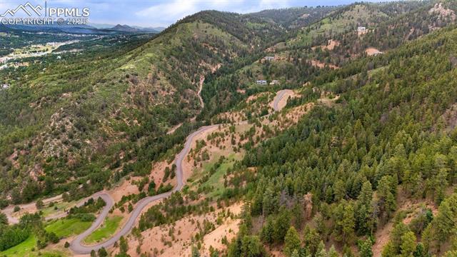 Aerial view of property and surrounding area with mountains and a heavily wooded area