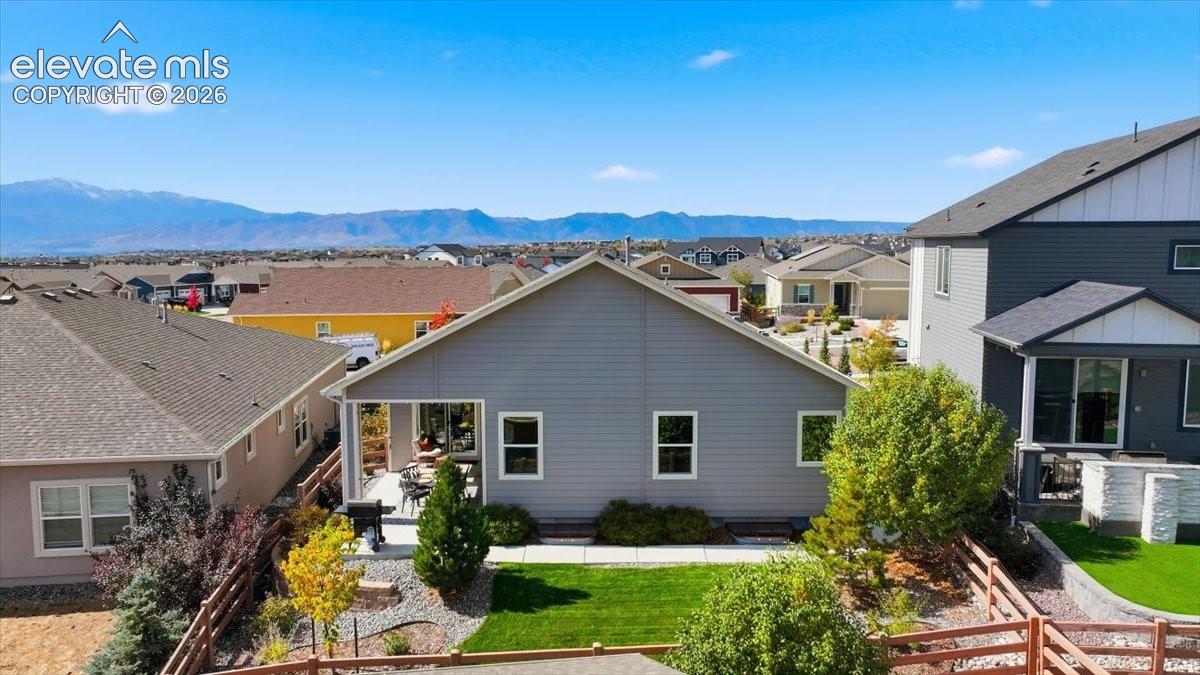 Mountain backdrop, covered patio, manicured lawn, established landscaping, privacy fencing