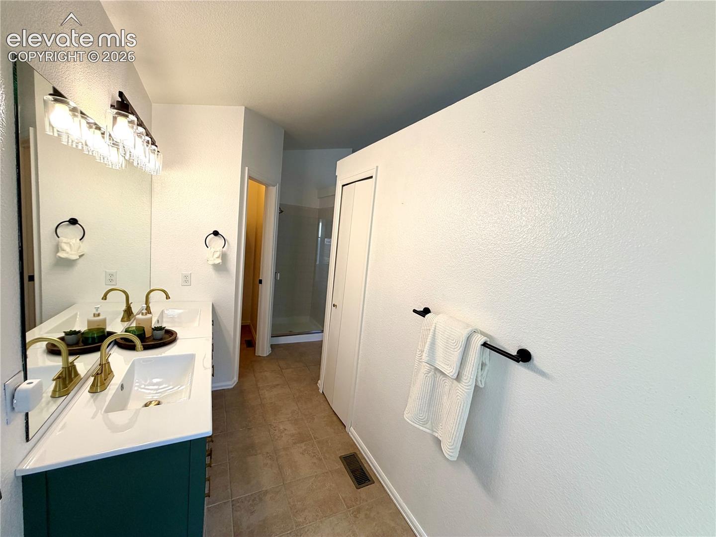 Double vanity with a white countertop and deep green cabinetry