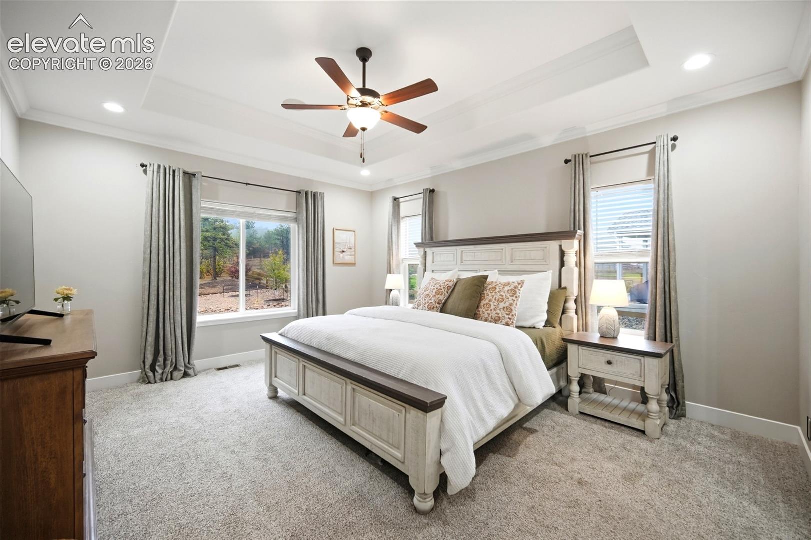 Tray ceiling, recessed lighting, and a ceiling fan with integrated light fixture