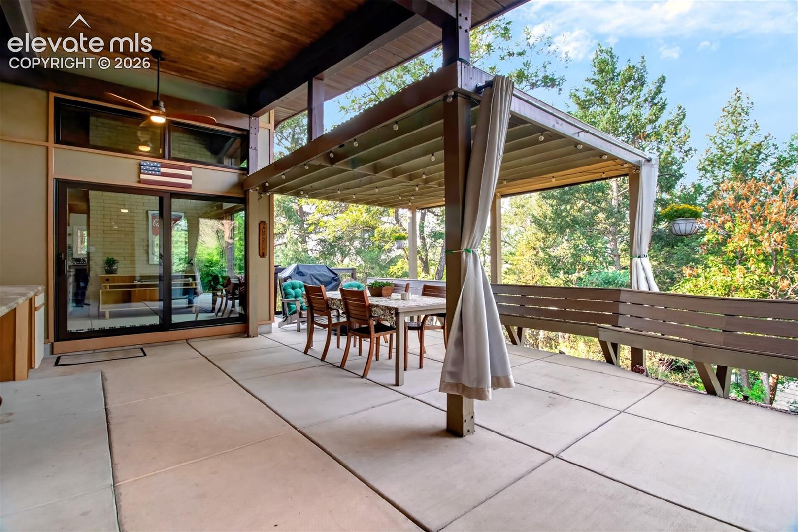 The large patio has a pergola for covered seating, and built-in bench eating