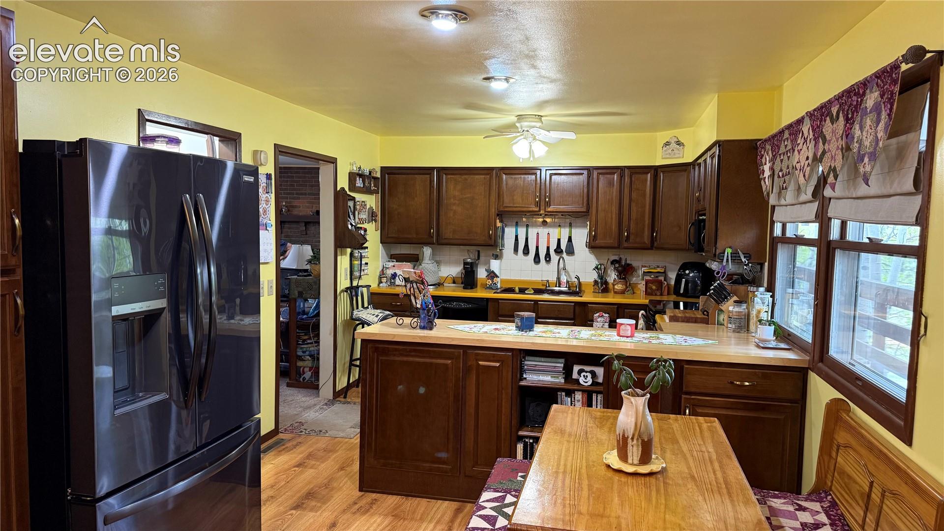 Kitchen featuring wood-finish flooring, dark wood cabinetry, and light countertops