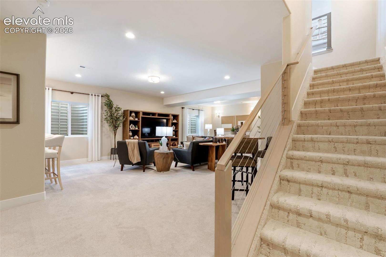 Open interior space featuring recessed lighting, carpeted flooring, and a built-in wooden media cabinet