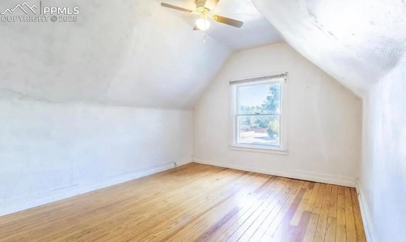 Additional living space with light wood finished floors, lofted ceiling, and ceiling fan