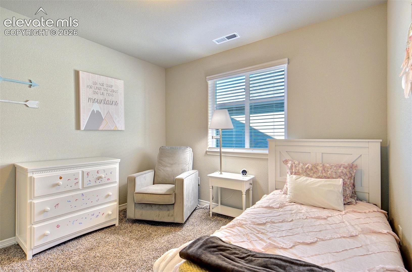 Neutral-toned interior space featuring neutral wall-to-wall carpeting and a single double-hung window with fitted blinds