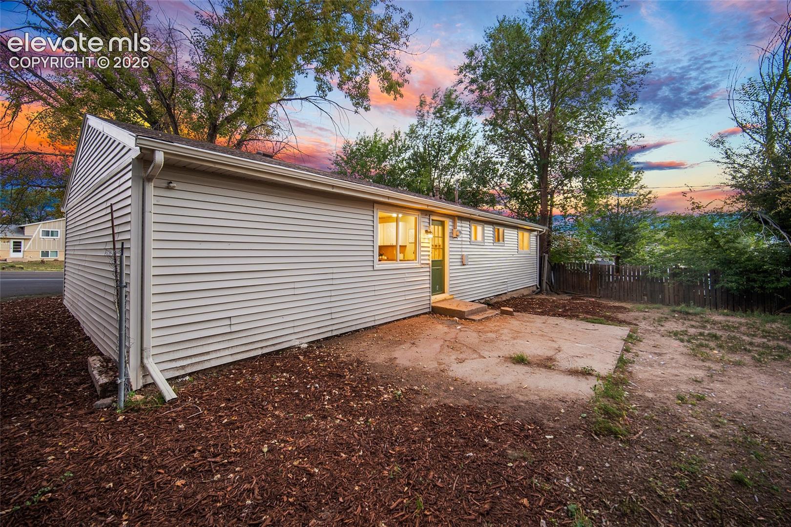 Rear exterior with horizontal siding, concrete patio, and a fenced perimeter