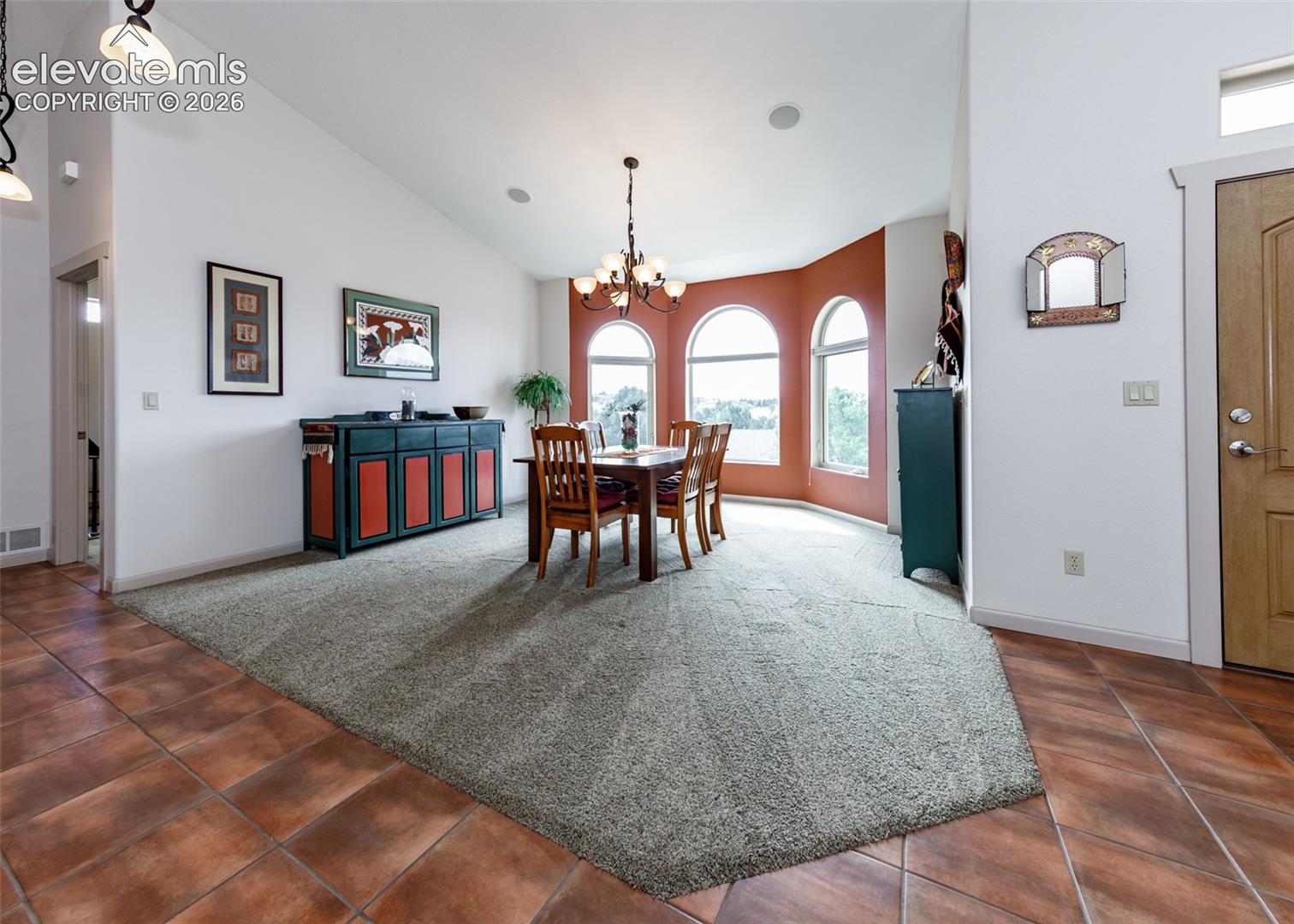 Vaulted ceilings complement the arched windows in this open, formal dining room