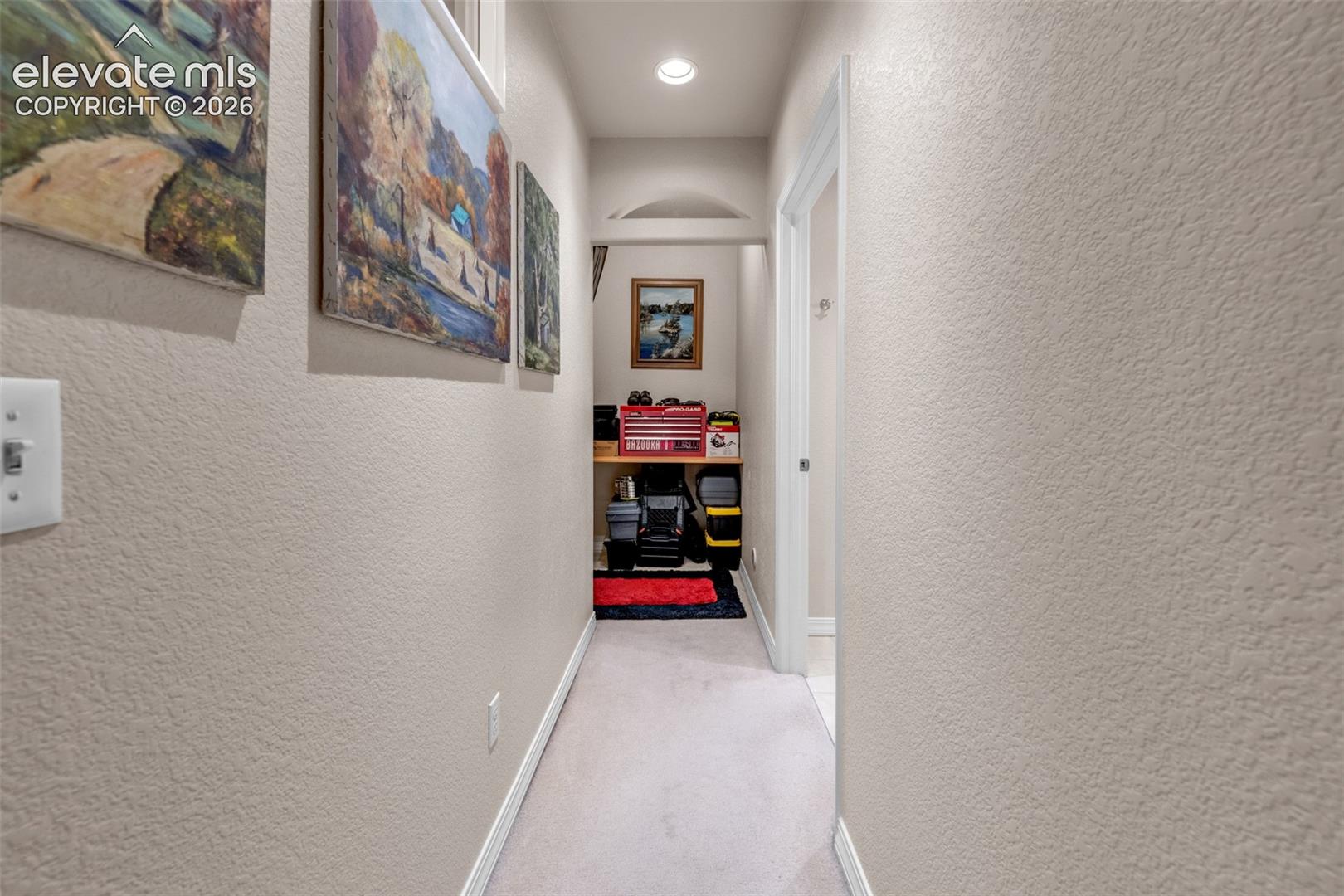 Arched doorway leading to a recessed area with built-in shelving, complemented by overhead recessed lighting