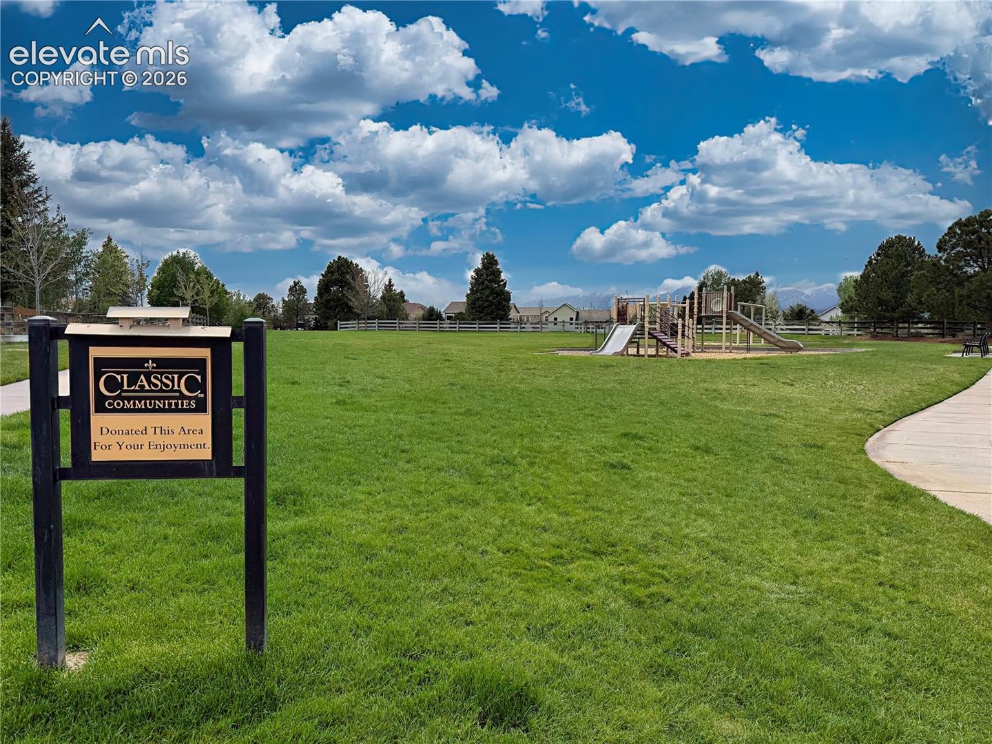 Expansive neighborhood park featuring walking paths, playground equipment, and beautifully maintained green space, ideal for outdoor recreation and gathering with neighbors.