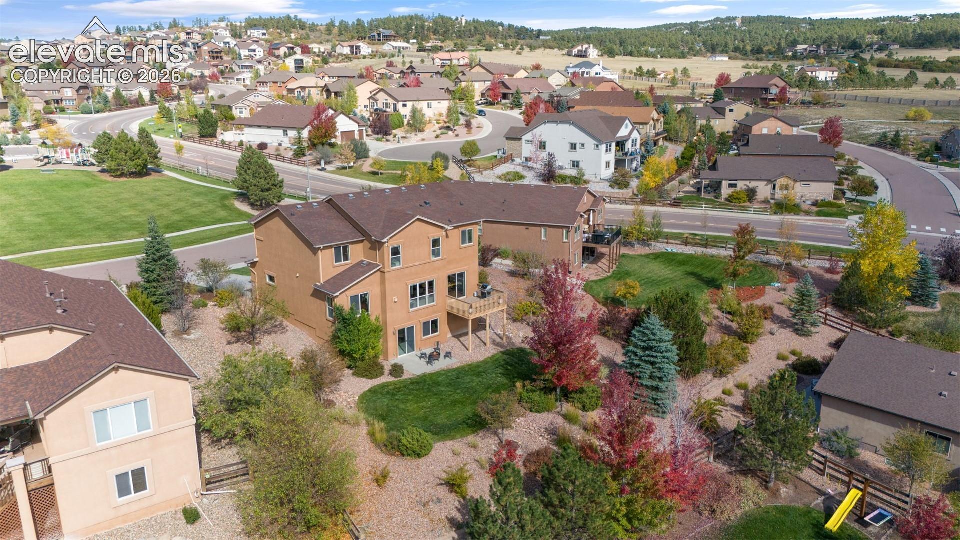 Multi-level exterior featuring a stucco facade, wood-frame deck, and asphalt shingle roof