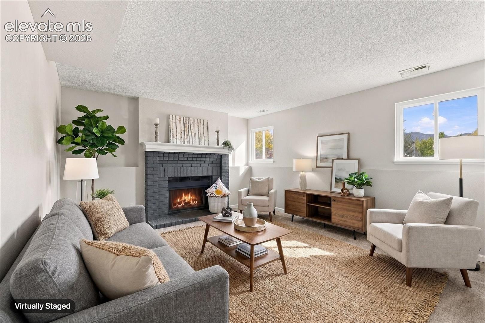 Living area featuring a floor-to-ceiling painted brick fireplace with a decorative mantel and double-pane windows