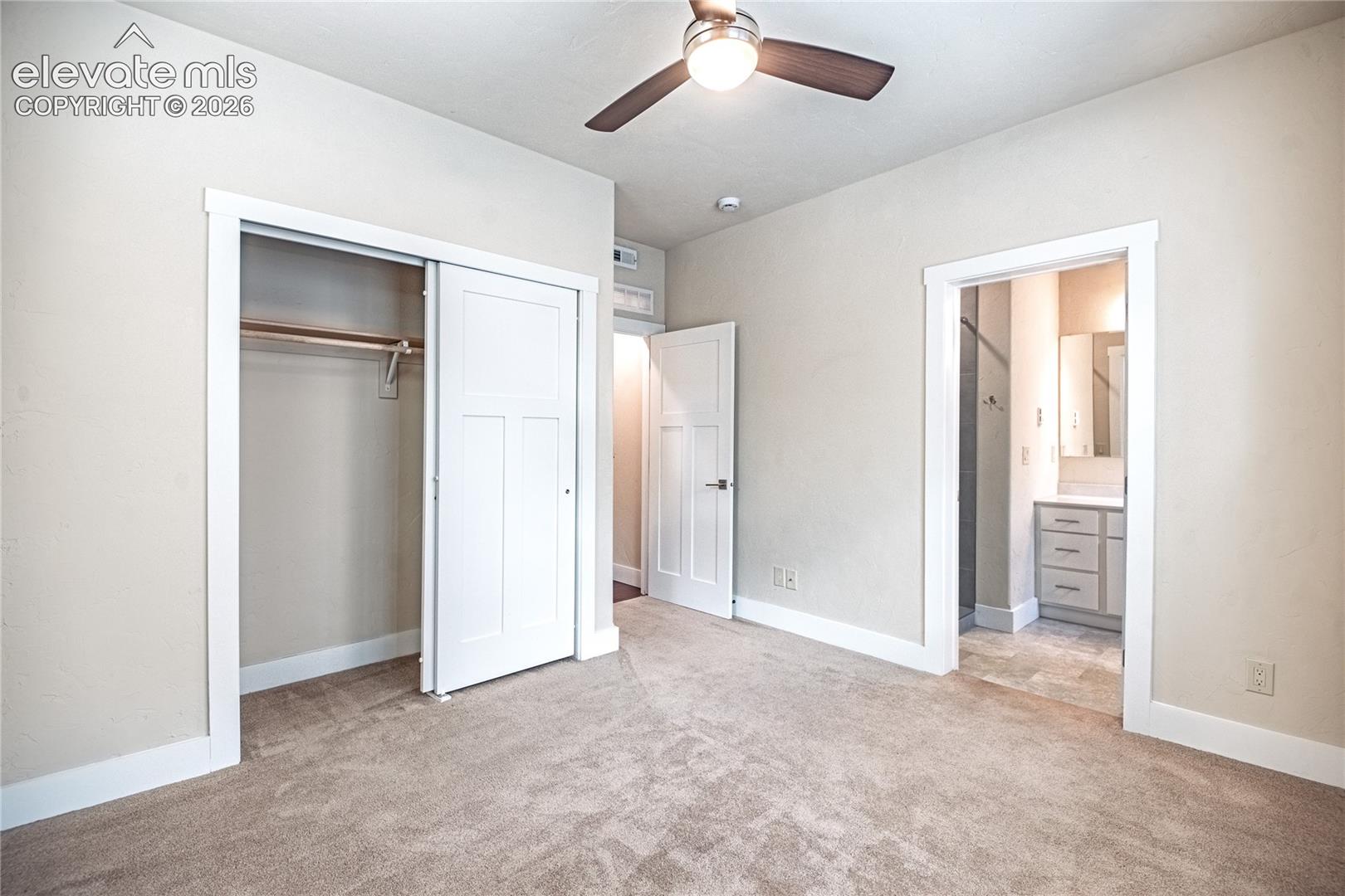Carpeted room with a ceiling fan