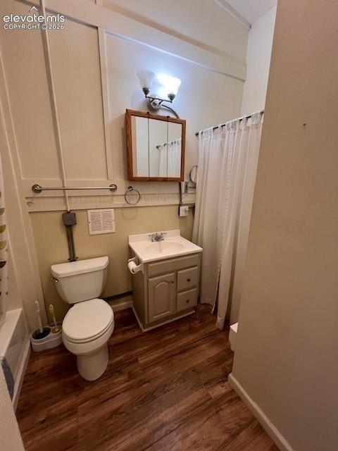Bathroom featuring wood-finish flooring, a vanity cabinet with an integrated sink, a wall-mounted medicine cabinet, and dual-light fixture