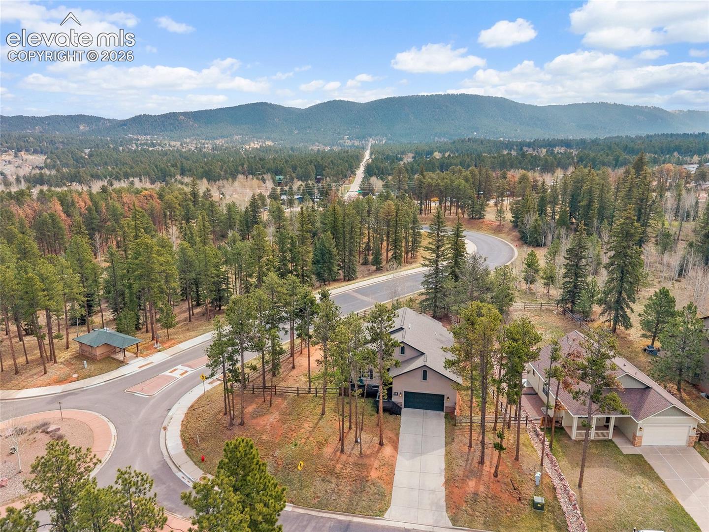 Aerial view of the home, neighborhood, and surrounding mountains