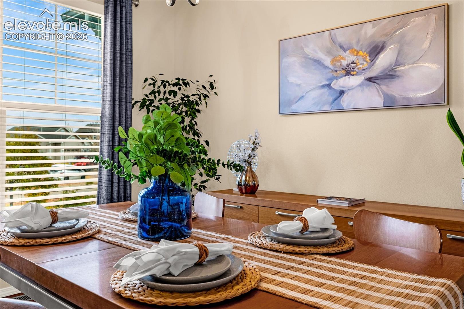 Neutral wall paint, large window with integrated blinds, and polished wood-finish surfaces
