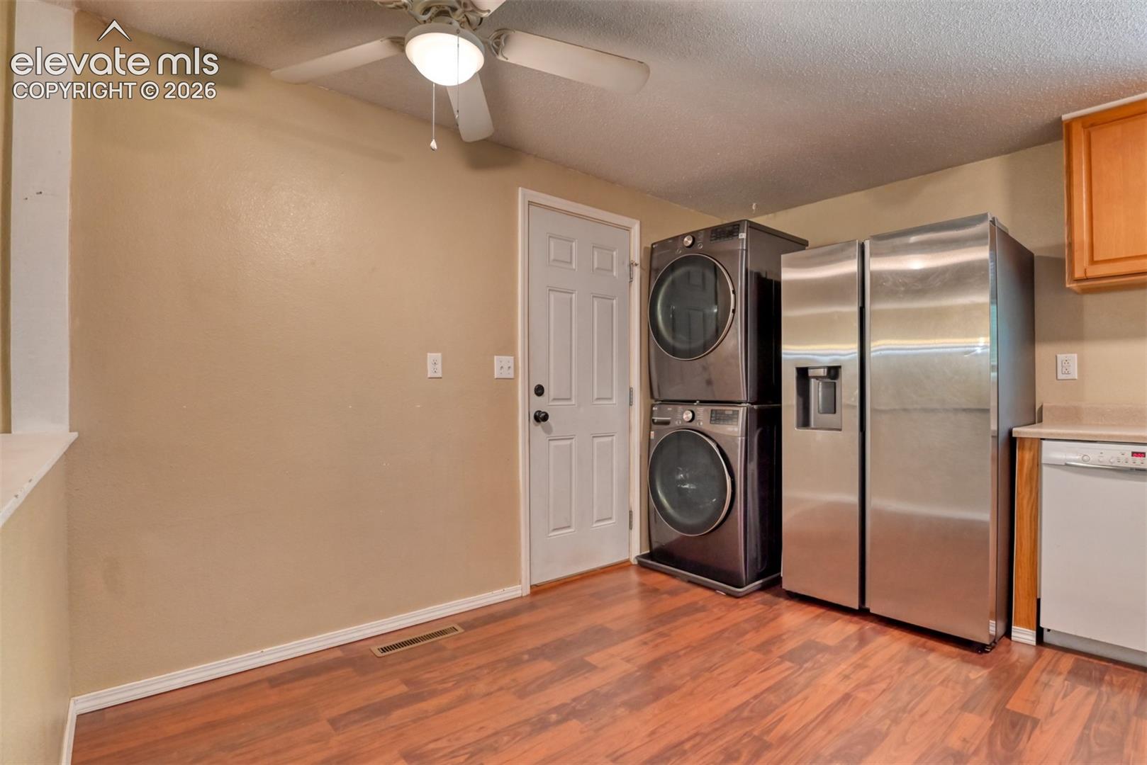 Kitchen area with wood-finish flooring, light beige wall paint, white trim, and a ceiling fan