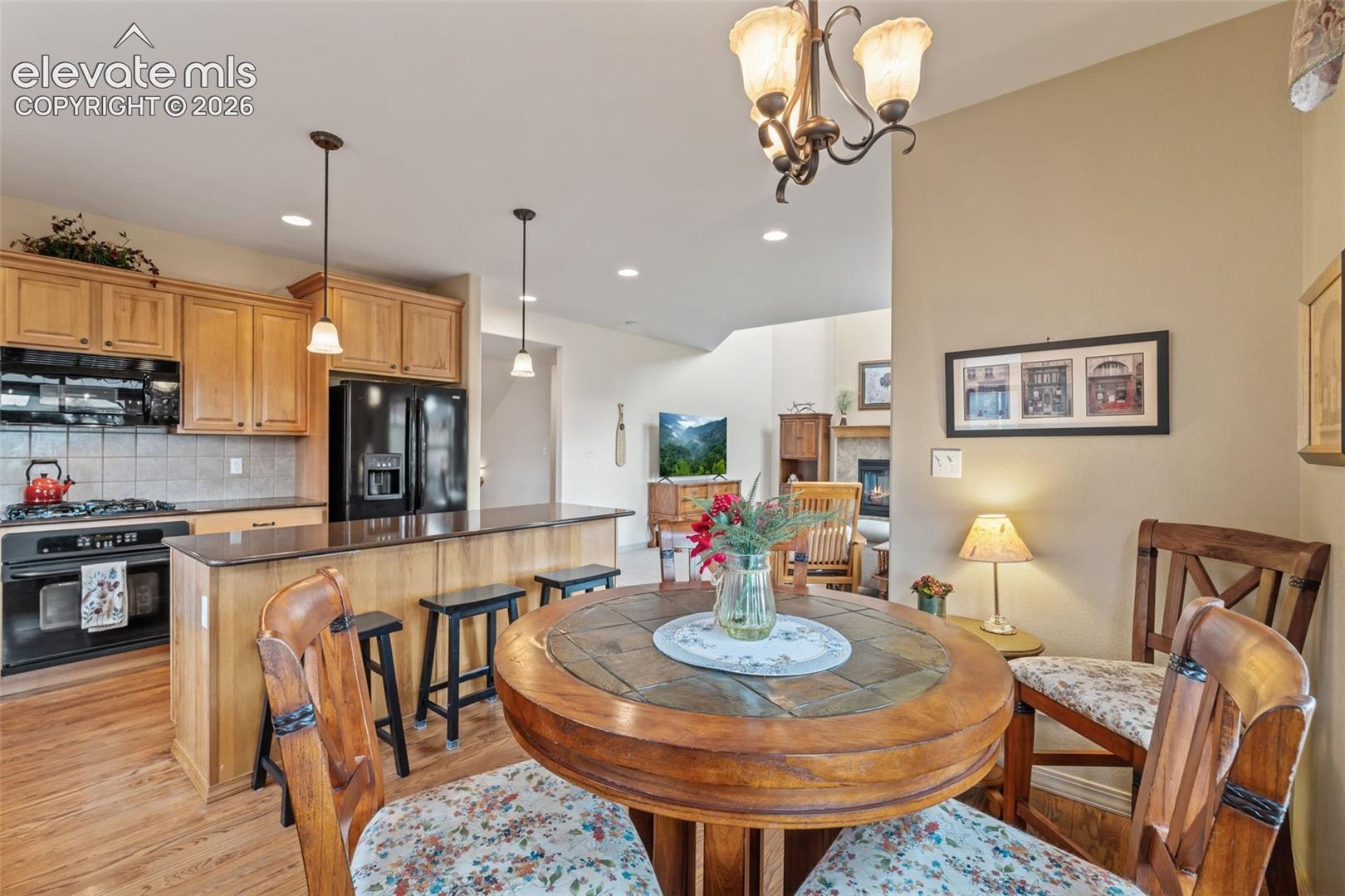 Kitchen featuring wood-finish cabinetry, black appliances, and a tiled backsplash